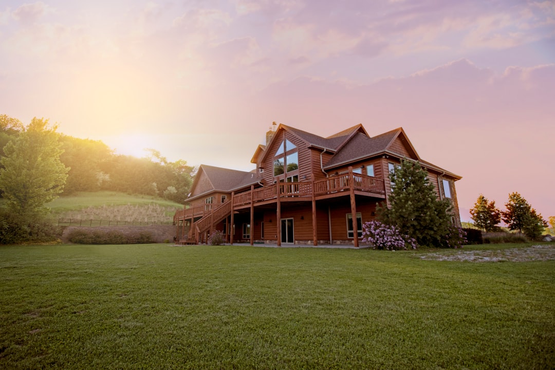 brown-wooden-house-with-green-grass-field-bkp3glygyea