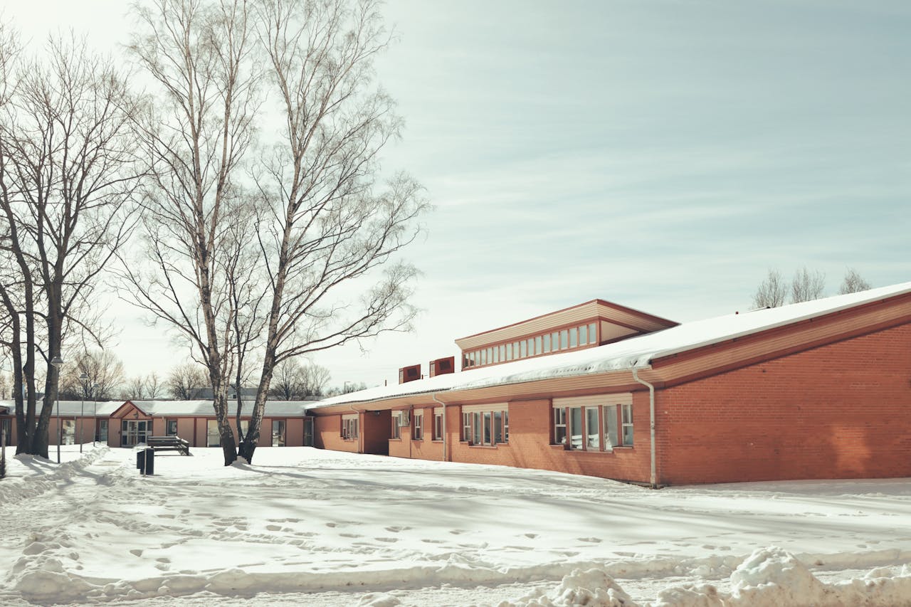 Winter landscape of a snow-covered building and trees in Jönköping, Sweden.