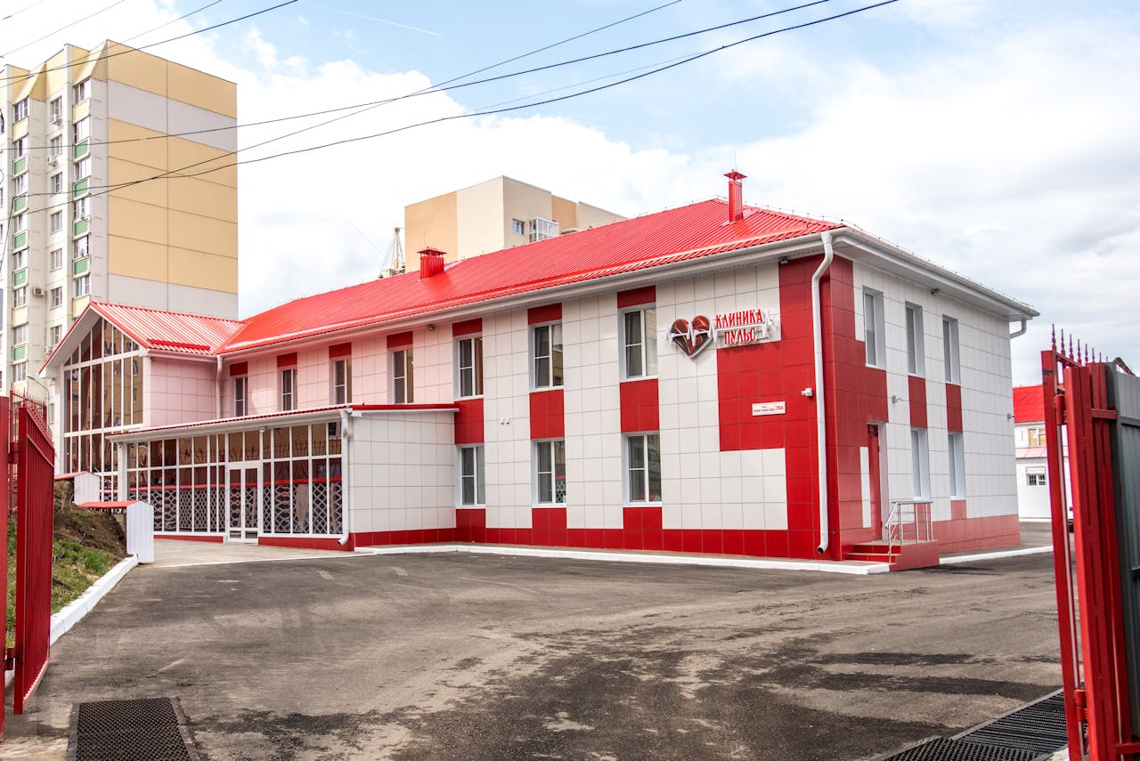 Modern clinic building with red and white facade, showcasing contemporary architecture.